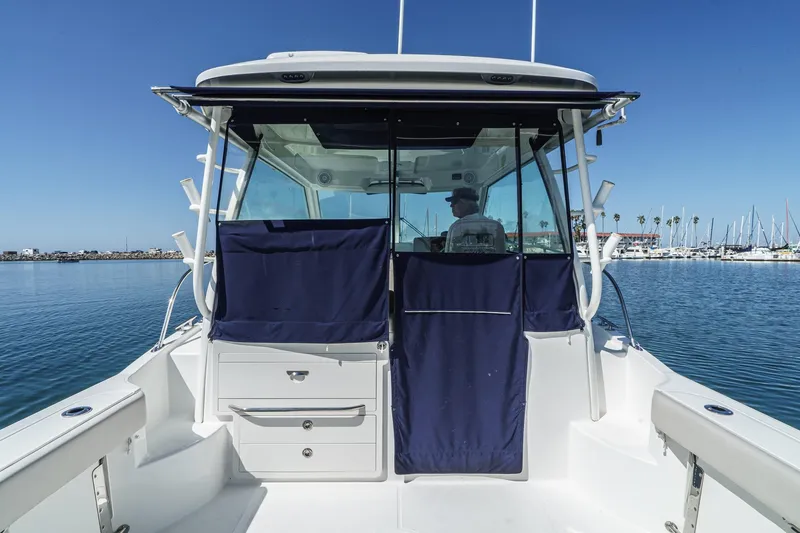 Slide: The Image of 2016 Boston Whaler 315 Conquest boat docked in a marina, featuring a spacious cockpit. - 17