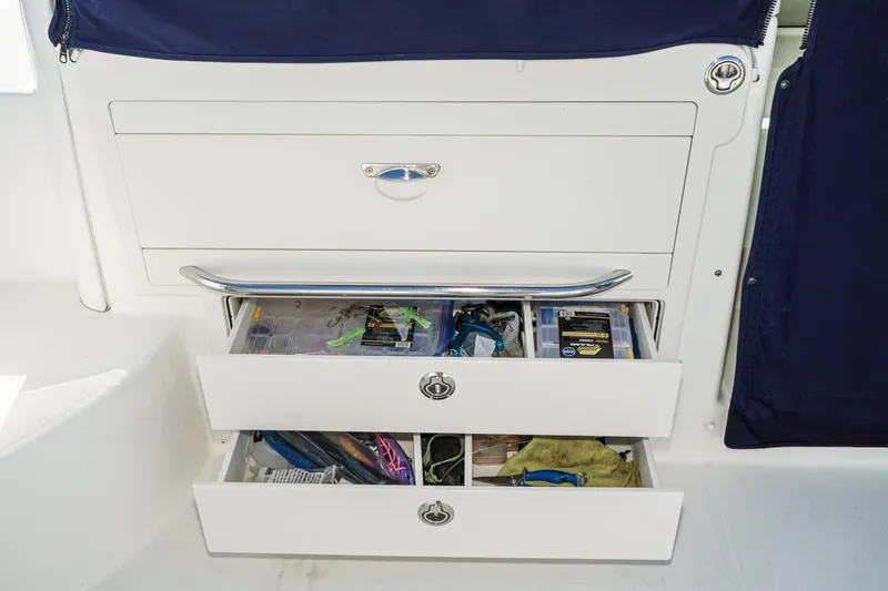 Slide: The Image of Storage drawers on a 2016 Boston Whaler 315 Conquest boat, containing fishing gear and tools. - 19