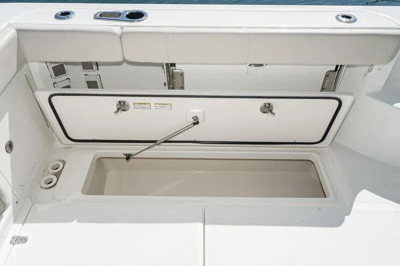 Slide: The Image of 2016 Boston Whaler 315 Conquest storage compartment with open hatch and clean interior. - 25