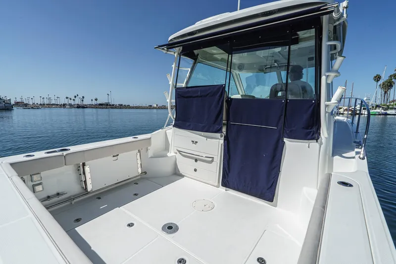 Slide: The Image of 2016 Boston Whaler 315 Conquest boat with spacious deck and marina view. - 27