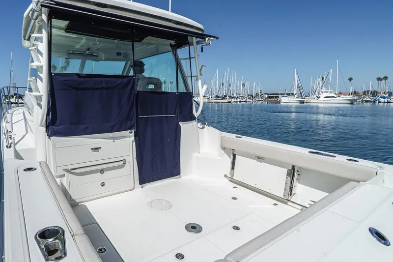Slide: The Image of 2016 Boston Whaler 315 Conquest boat docked in a marina, showcasing spacious deck area. - 28