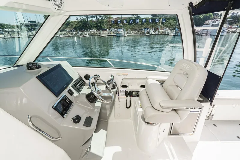 Slide: The Image of Interior of 2016 Boston Whaler 315 Conquest boat, featuring helm and captain's chair. - 31