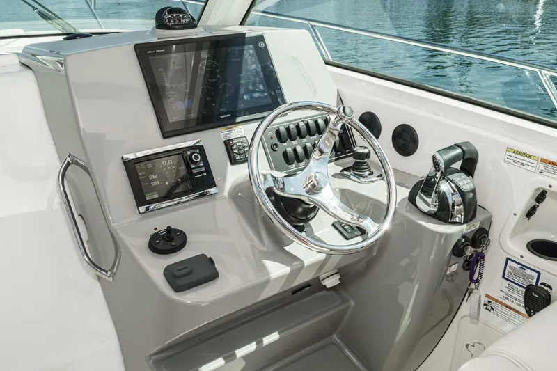 Slide: The Image of Control panel of a 2016 Boston Whaler 315 Conquest boat with steering wheel and navigation displays. - 32