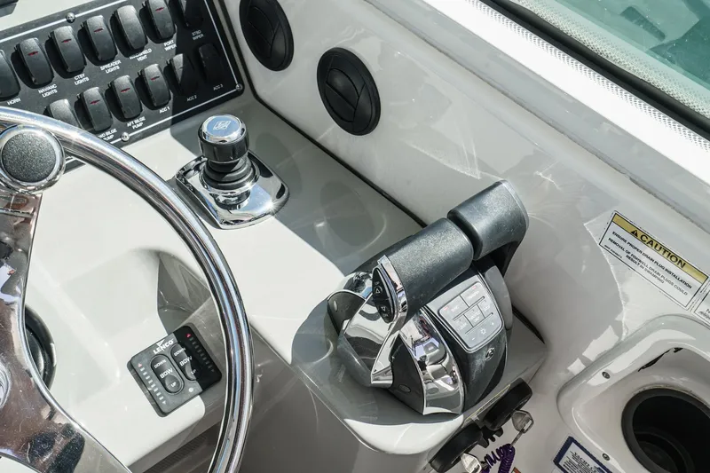 Slide: The Image of Control panel of 2016 Boston Whaler 315 Conquest boat, featuring steering wheel and throttle controls. - 36