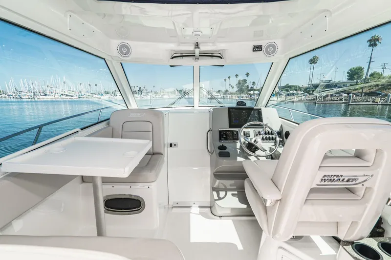 Slide: The Image of Interior of 2016 Boston Whaler 315 Conquest boat, featuring helm and seating area. - 41