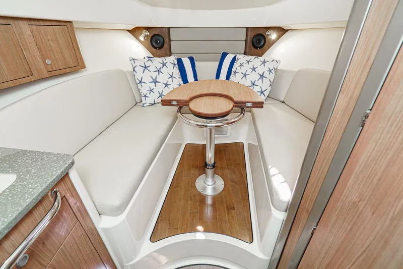 Slide: The Image of 2016 Boston Whaler 315 Conquest cabin interior with cozy seating and nautical decor. - 46