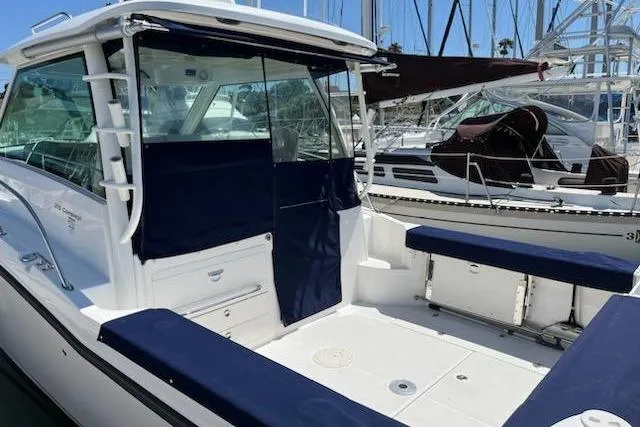 Slide: The Image of 2016 Boston Whaler 315 Conquest boat docked, featuring spacious seating and covered cockpit. - 48