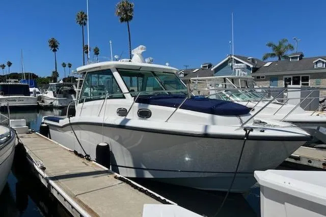Slide: The Image of 2016 Boston Whaler 315 Conquest docked at a marina with palm trees. - 51