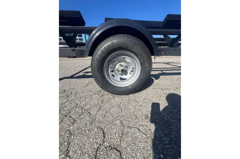 Slide: The Image of Trailer wheel of 2025 Sun Tracker Party Barge 18 DLX on cracked pavement. - 3