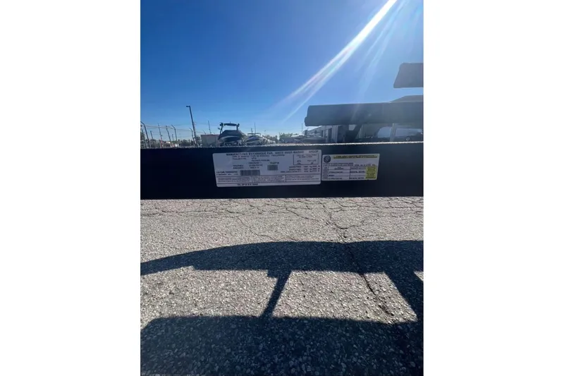 Slide: The Image of 2025 Sun Tracker Party Barge 18 DLX trailer label under bright sunlight. - 4