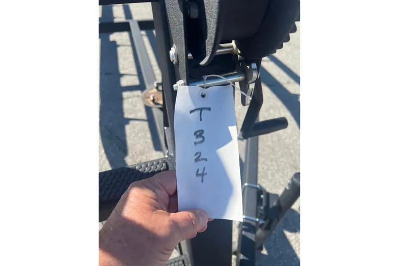 Slide: The Image of Hand holding a tag labeled "T324" on a 2025 Sun Tracker Party Barge 18 DLX. - 5