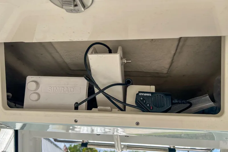 Slide: The Image of 2023 Robalo 266 Cayman boat compartment with Simrad electronics and wiring. - 10