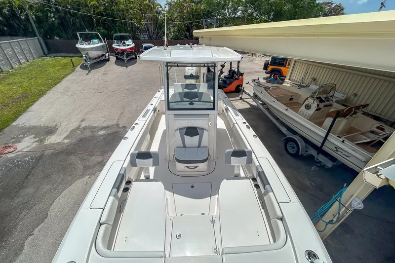 Slide: The Image of 2023 Robalo 266 Cayman boat in a marina, showcasing spacious deck and seating. - 12