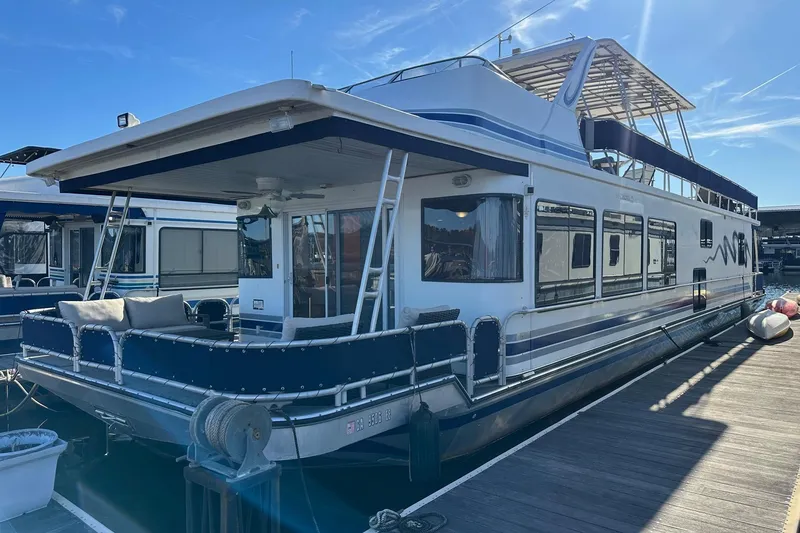 The Image of 2000 Sumerset 16x73 houseboat docked, featuring spacious deck and modern design. - 0