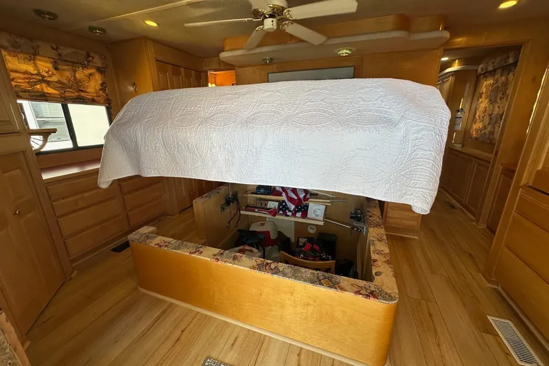 Slide: The Image of Interior of 2000 Sumerset 16x73 houseboat with raised bed and wooden cabinetry. - 12