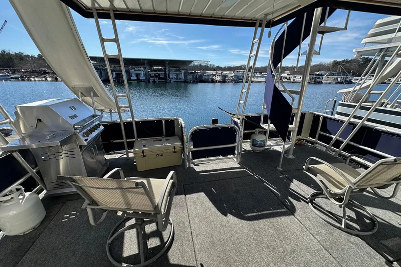 Slide: The Image of Outdoor deck of 2000 Sumerset 16x73 houseboat with chairs and grill by the water. - 14