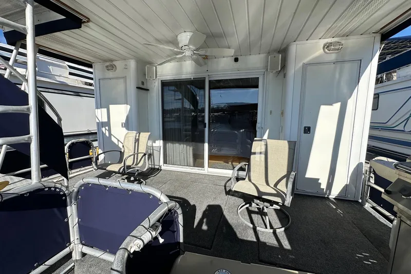 Slide: The Image of Outdoor seating area on a 2000 Sumerset 16x73 houseboat with chairs and sliding glass door. - 15