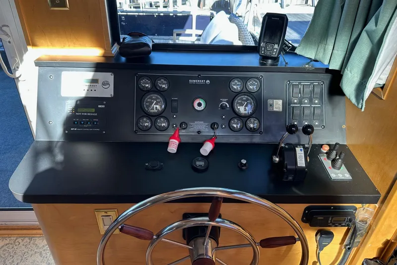 Slide: The Image of Control panel of a 2000 Sumerset 16x73 houseboat with steering wheel and gauges. - 2