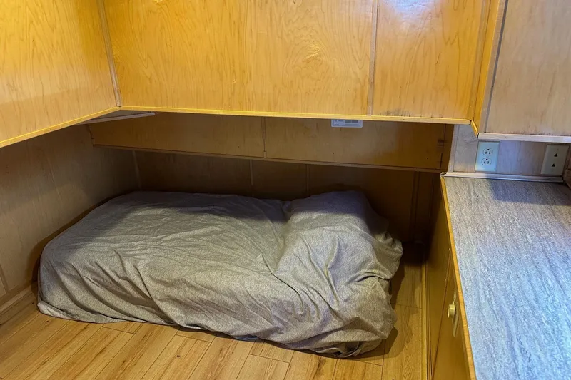 Slide: The Image of Small sleeping area with wooden cabinets in a 2000 Sumerset 16x73 houseboat. - 9
