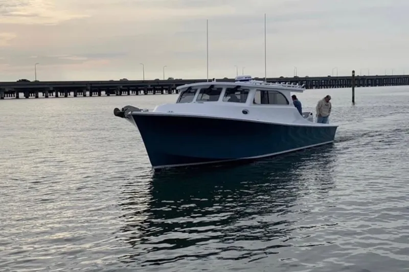 Slide: The Image of 2024 Composite Yacht CY 42 cruising on calm waters near a bridge at sunset. - 3
