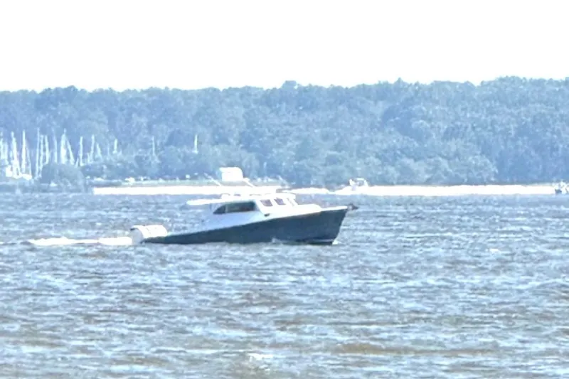 Slide: The Image of 2024 Composite Yacht CY 42 cruising on a scenic lake with forested shoreline. - 4