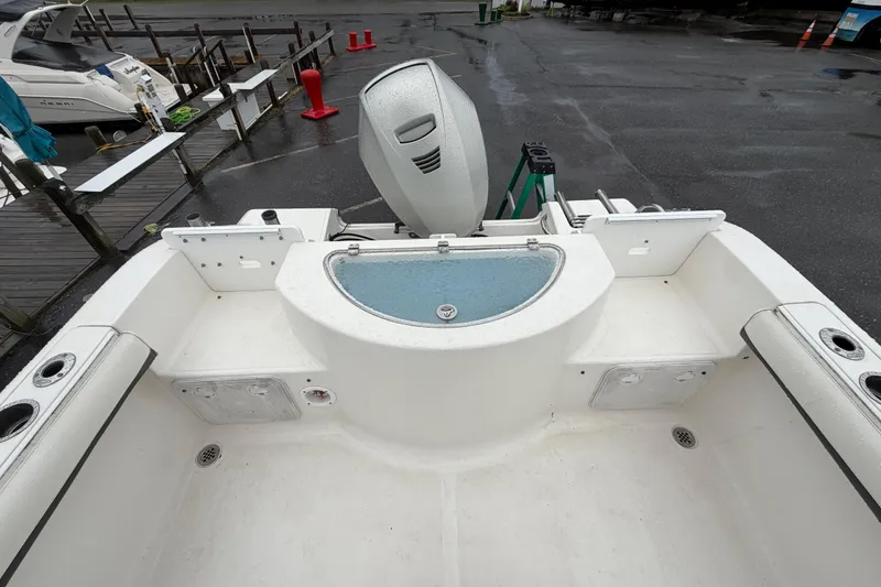 Slide: The Image of 2010 Sea Fox 216 Center Console boat interior with livewell and motor at dock. - 15