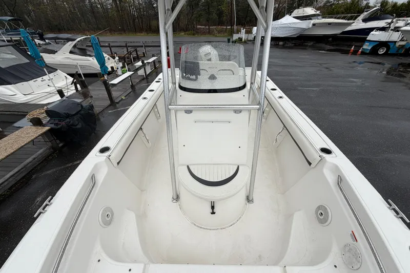 Slide: The Image of 2010 Sea Fox 216 Center Console boat docked, showcasing spacious interior and helm. - 24