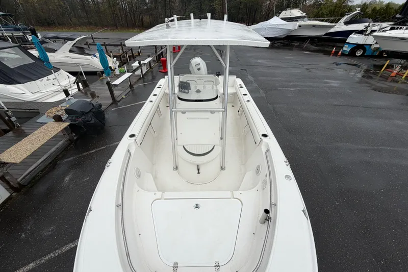 Slide: The Image of 2010 Sea Fox 216 Center Console boat docked, showcasing spacious deck and T-top. - 25