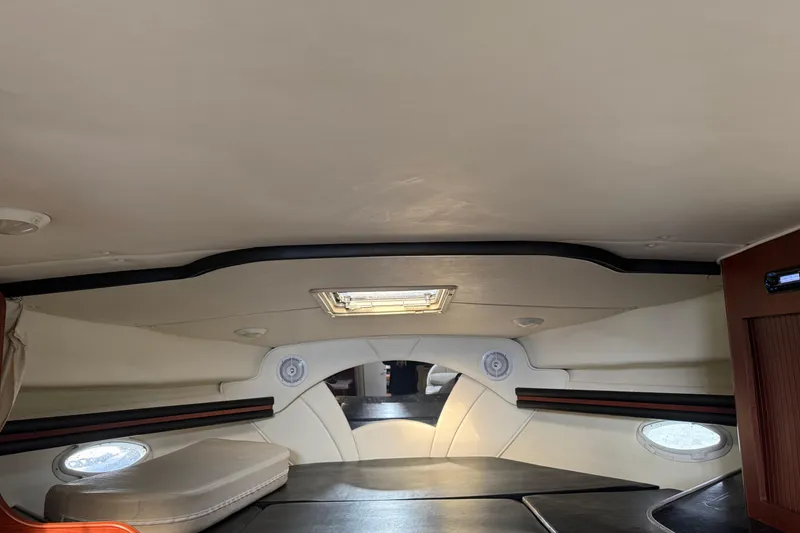 Slide: The Image of Interior cabin of 2002 Rinker Fiesta Vee 342 boat, featuring seating and portholes. - 16
