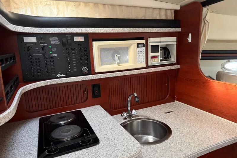 Slide: The Image of 2002 Rinker Fiesta Vee 342 galley with stove, sink, microwave, and coffee maker. - 18