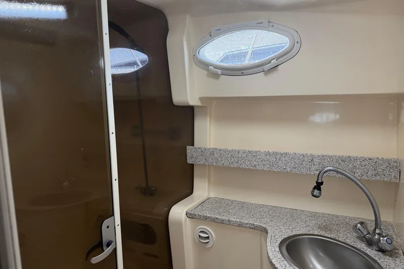Slide: The Image of 2002 Rinker Fiesta Vee 342 bathroom with sink, shower, and oval window. - 19
