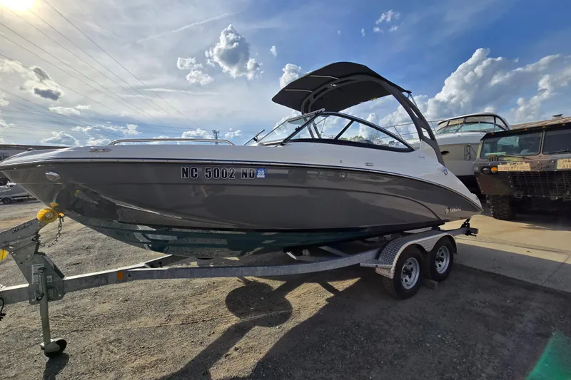 Slide: The Image of 2022 Yamaha Boats 212S on trailer under a sunny sky. - 1