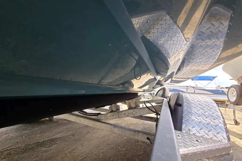 Slide: The Image of Underneath view of a 2022 Yamaha Boats 212S on a trailer, showcasing hull and trailer details. - 10