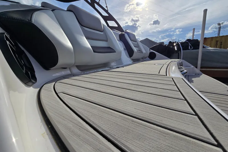 Slide: The Image of 2022 Yamaha Boats 212S deck with sleek seating and modern design under a sunny sky. - 15