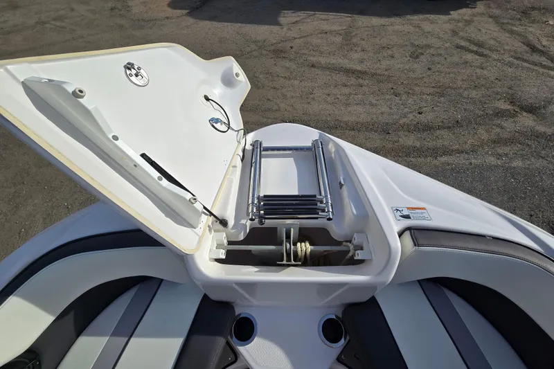 Slide: The Image of 2022 Yamaha Boats 212S bow with open storage compartment and ladder. - 19