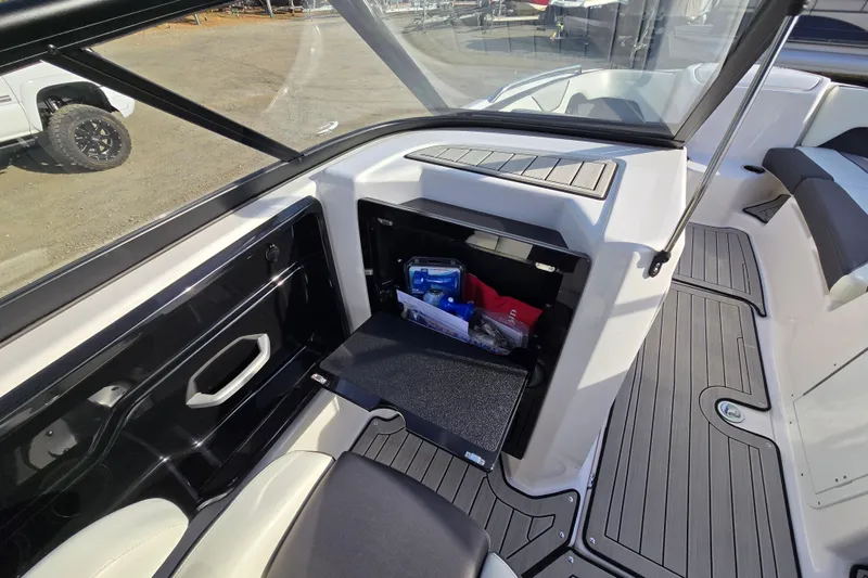 Slide: The Image of 2022 Yamaha Boats 212S interior storage compartment with open hatch and visible contents. - 26