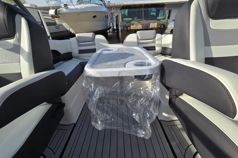 Slide: The Image of Interior of a 2022 Yamaha Boats 212S with seating and a covered table. - 36