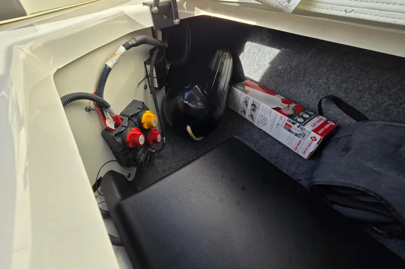 Slide: The Image of Storage compartment of a 2022 Yamaha Boats 212S, featuring wiring and accessories. - 42