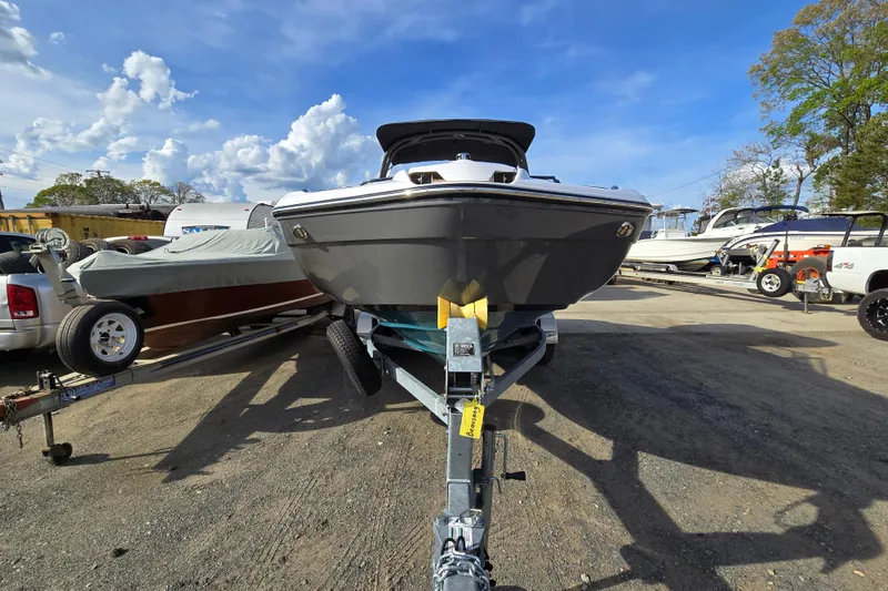 Slide: The Image of 2022 Yamaha Boats 212S on trailer under clear blue sky at a boatyard. - 5