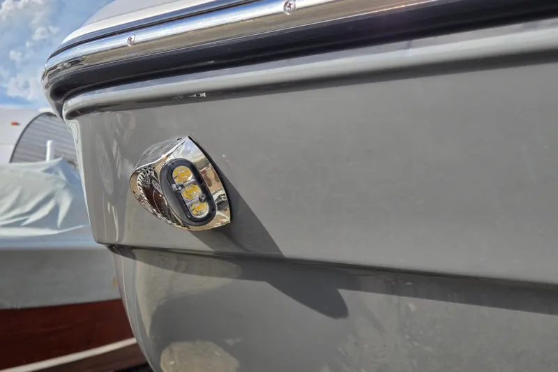 Slide: The Image of 2022 Yamaha Boats 212S close-up of LED light on sleek gray hull. - 8