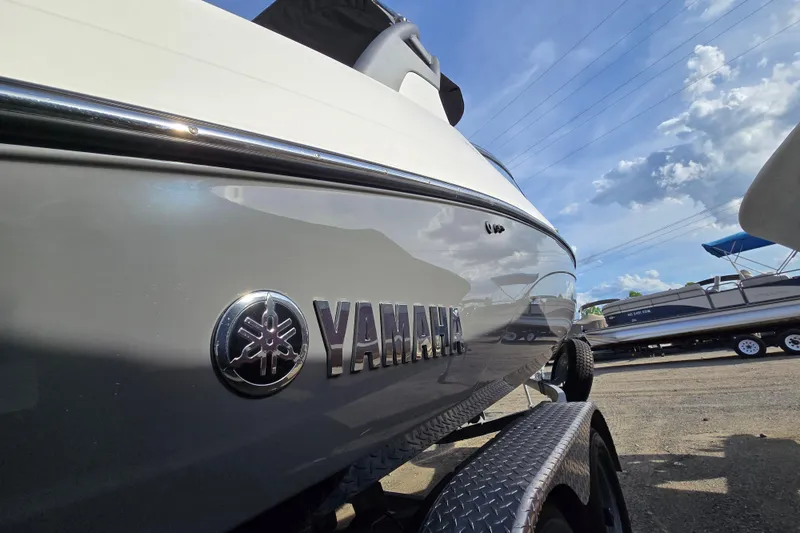 Slide: The Image of 2022 Yamaha Boats 212S, sleek design, parked outdoors under a blue sky. - 9
