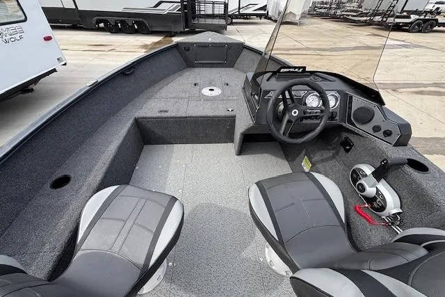 Slide: The Image of 2024 Lund 1650 Rebel XL Sport boat interior with steering console and seating. - 10