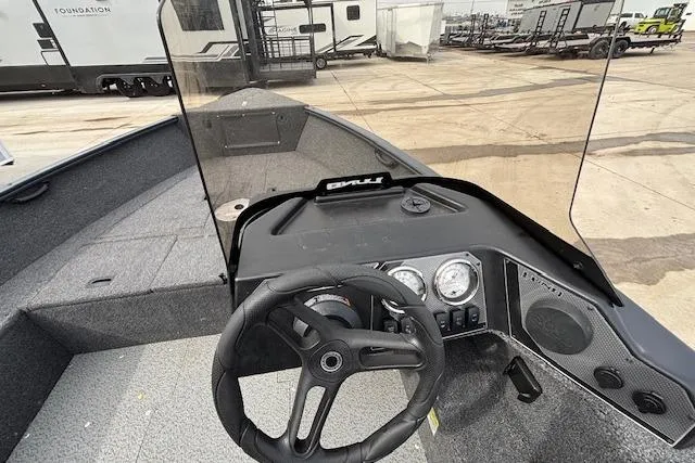 Slide: The Image of 2024 Lund 1650 Rebel XL Sport boat dashboard with steering wheel and gauges. - 15
