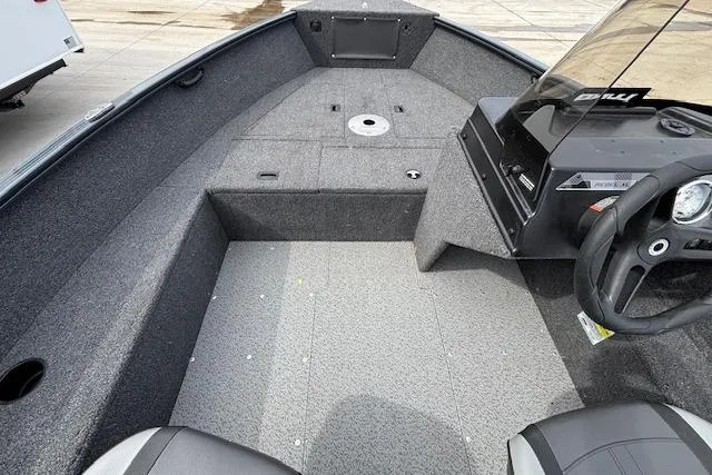 Slide: The Image of 2024 Lund 1650 Rebel XL Sport boat interior with steering console and seating area. - 16