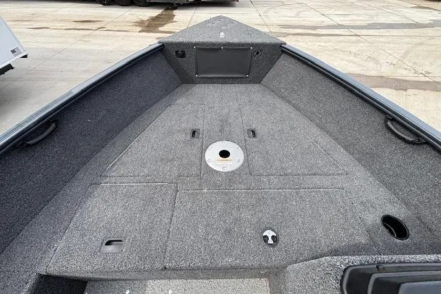 Slide: The Image of 2024 Lund 1650 Rebel XL Sport boat interior with gray carpeted deck. - 17