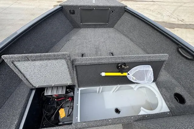 Slide: The Image of 2024 Lund 1650 Rebel XL Sport boat interior with storage compartments and fishing net. - 18