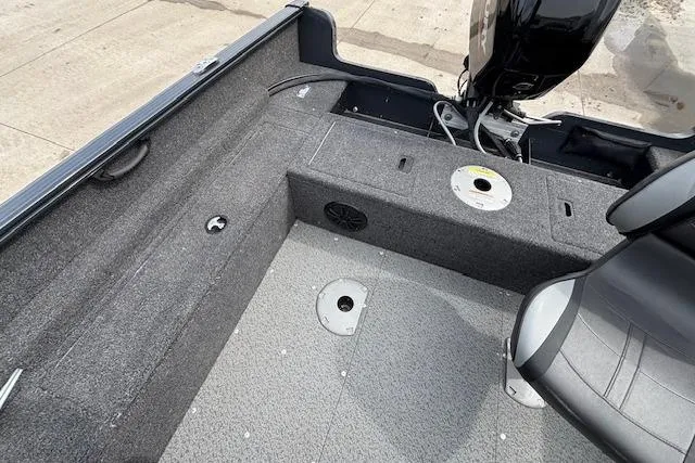 Slide: The Image of 2024 Lund 1650 Rebel XL Sport boat interior with seating and motor view. - 26