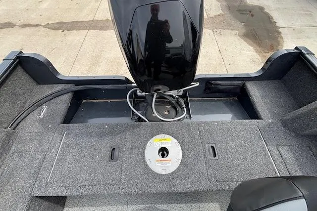 Slide: The Image of 2024 Lund 1650 Rebel XL Sport boat interior with motor and carpeted deck. - 28