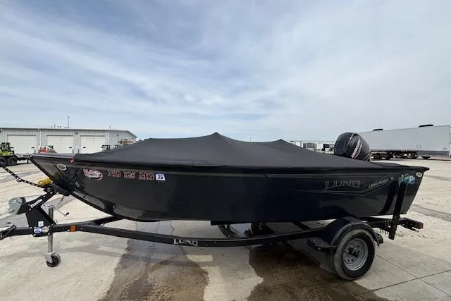 Slide: The Image of 2024 Lund 1650 Rebel XL Sport boat on trailer, covered, in outdoor setting. - 4