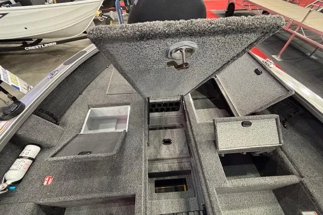 Slide: The Image of 2026 Crestliner 1850 Pro Tiller boat interior with open storage compartments and carpeted flooring. - 11